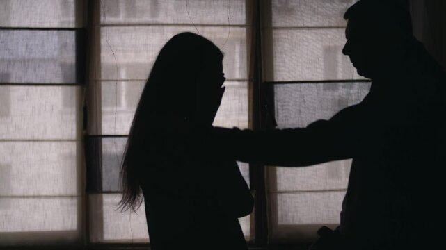 Silhouettes of a sad couple. A Man supports and hugs upset woman. difficulties in relationships. Crisis. Sadness. Family problems