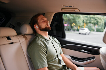 Relaxed man in car with headphones enjoying calm moments