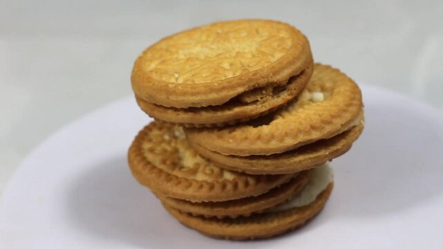 Stacked layered biscuit cakes filled with cream frosting stacked on rotating display