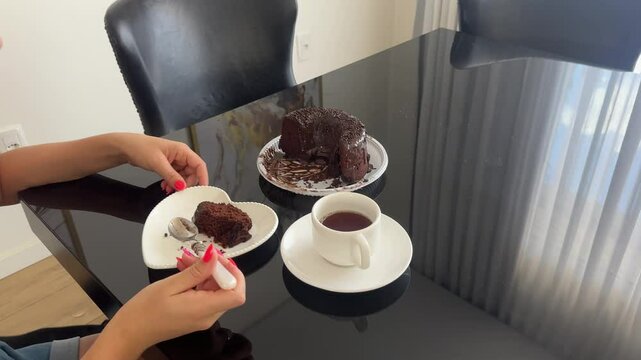 mulher toma caf&eacute; e come bolo de chocolate 