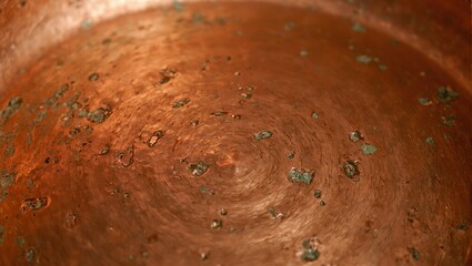 Rustic hand beaten copper cookware with warm orange and gold tones showcasing artisanal craftsmanship