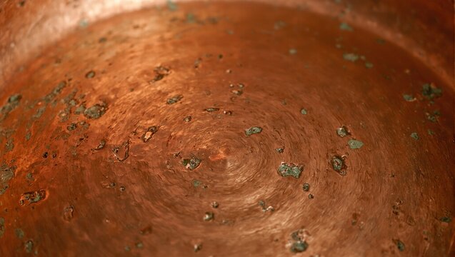 Rustic hand beaten copper cookware with warm orange and gold tones showcasing artisanal craftsmanship