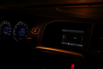 Car interior, control panel of audio player and other devices close-up, automobile dashboard of car driving at night