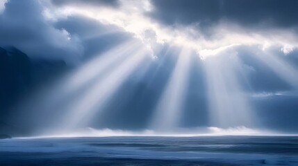 Dramatic sun rays breaking through dark clouds over ocean.