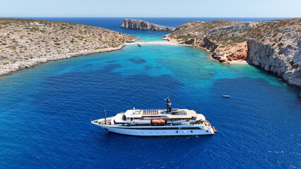 Aerial drone photo of luxury yacht anchored in tropical exotic island bay with emerald sea and...