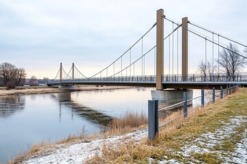 Fototapeta premium Suspension bridge over river, winter, calm