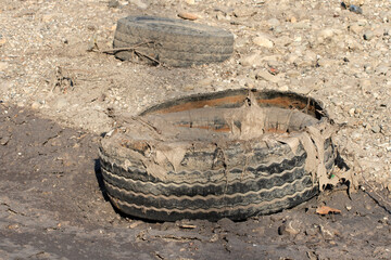 An example of water pollution, truck tire debrises left in a river bed as the water recedes.