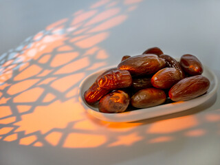 An arabesque shade and dates on a saucer, ready to eat during iftar. Holy month of Ramadan Karim for Muslims. Ramadan Mubarak. Islamic religion.