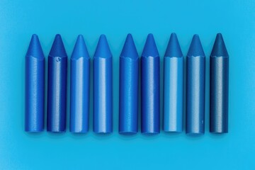 Fototapeta premium Spectrum of Blue Crayons: A Visual Display of Vivid Hues Against a Matching Background