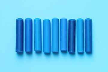 Fototapeta premium Spectrum of Blue Crayons: A Row of Vivid Shades Against a Matching Blue Backdrop
