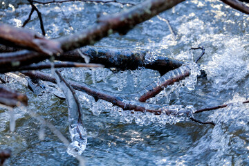 River and ice on branches flowing water nature background