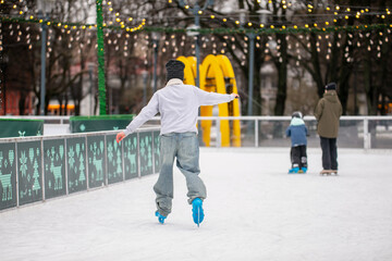 People ice skating outdoor rink during cold winter days having fun without falling painfully 