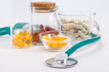 Stethoscope and pills on a white background. Focus on foreground.