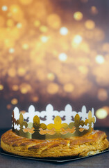 Fresh almond royal galette with crown on table with bokeh.
