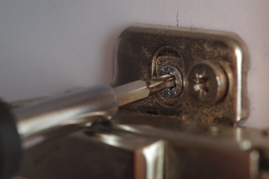 homemade diy: a torx screwdriver while tigh the retaining screw of a cabinet hinge