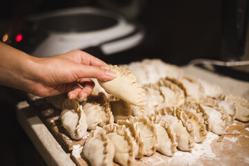 Making dumplings. Homemade dumplings. Raw dumplings. Cooking process. Dough product. Flour, dough, filling. Making by hand. Ukrainian dish. Vareniki with potatoes.