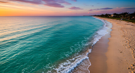 Tranquil Beach at Sunset: Serene Ocean Waves Gently Washing Onto the Sandy Shore Under a Vibrant Sky with Warm Orange and Cool Blue Hues