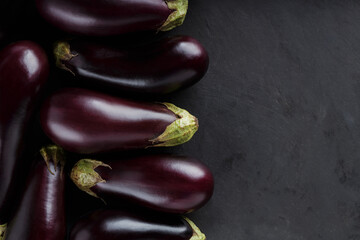 Fresh Farm-to-Table Eggplants on Dark Surface for Rural Economy and Organic Farming, Top View, Copy Space