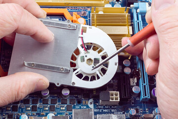 Repair the motherboard in the workshop. Hands of the master, close-up with tools repair...