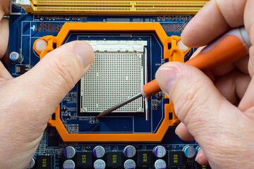 Repair the motherboard in the workshop. Hands of the master, close-up with tools repair...