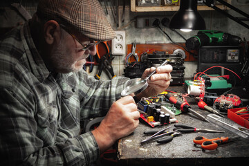 Technician repairing a computer in a workshop. Selective focus.