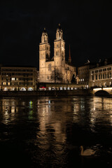 Obraz premium Nighttime View of Historic City Center with Illuminated Cathedral and Buildings in Zurich