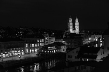 Fototapeta premium Nighttime View of Historic City Center with Illuminated Cathedral and Buildings in Zurich