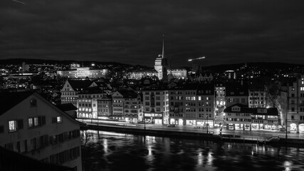 Obraz premium Nighttime View of Historic City Center with Illuminated Cathedral and Buildings in Zurich