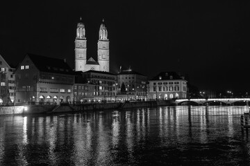Fototapeta premium Nighttime View of Historic City Center with Illuminated Cathedral and Buildings in Zurich