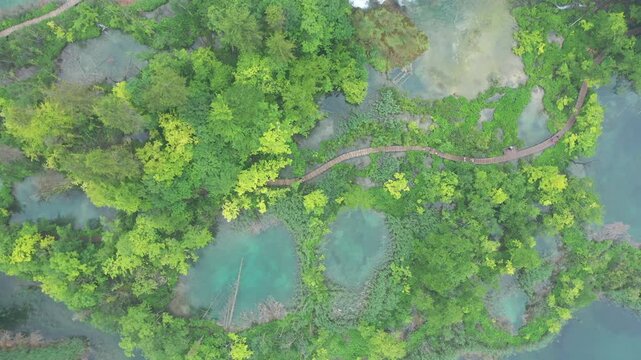 Aerial footage of Plitvice Lakes, a UNESCO World Heritage site in Croatia, showcasing stunning waterfalls, clear lakes, and verdant forests.