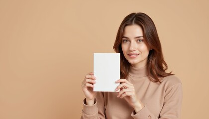 Fototapeta premium Woman showing a product packaging mockup with a soft beige backdrop