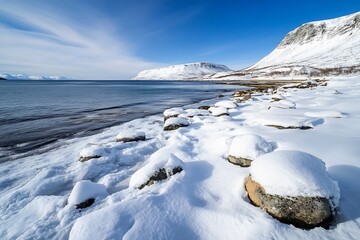 Obraz premium Pristine Arctic Landscape of Snowy Shoreline and Icy Waters Under Blue Sky : Generative AI