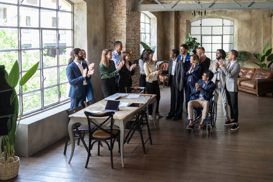 Diverse business team celebrating success in a modern industrial office setting