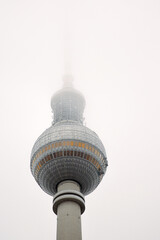 Berlin TV tower in dense fog, iconic Alexanderplatz landmark disappearing into mist. Foggy...