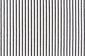 Close-up of whte fabric with vertical black stripes filling the frame.