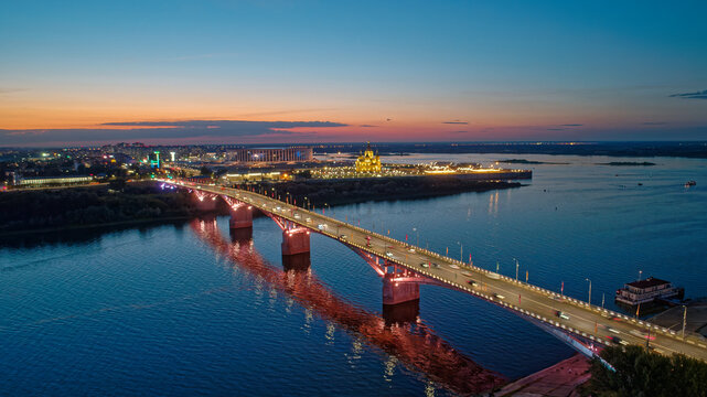 Bridge spans a river with a city in the background
