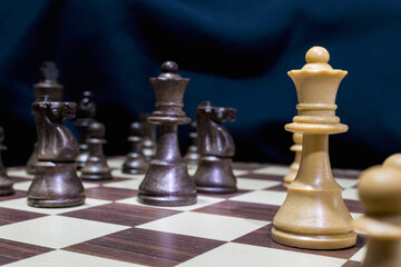 Chessmen photographed on a chessboard with a dark background
