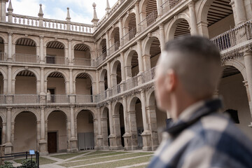 Obraz premium Non-binary person admiring the architecture of the irish college.