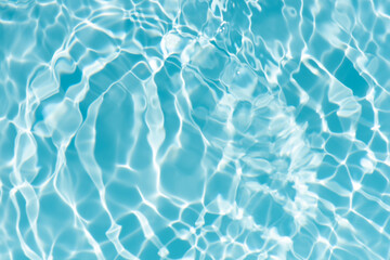 Blue water with ripples on the surface. Defocus blurred transparent blue colored clear calm water surface texture with splashes and bubbles. Water waves with shining pattern texture background.