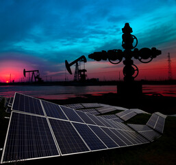 Oil pump with solar panels in the sunset