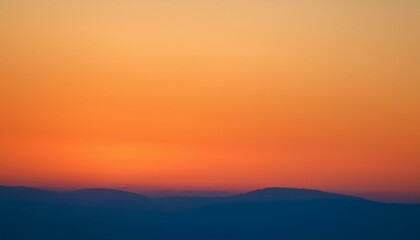 Fototapeta premium Fiery sunset over a distant mountain range.