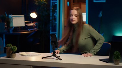 Content creator arriving in studio, using smartphone on tripod to shoot introductory segment for vlog channel. Media star greeting devoted fan community, introducing today video subject, camera A