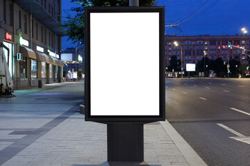 Vertical billboard advertising in the night city. Shops on the ground floor. Mock-up.