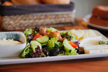 A Fresh Salad Platter with Hummus and Bread delights the palate