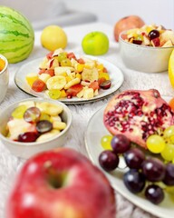 Fruchtiger Obstsalat mit tropischen Früchten Melone Apfel Birne Weintrauben Banane Granatapfel Orange Mandarine