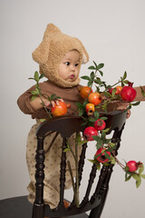there is a baby sitting on a chair with a teddy bear hat on