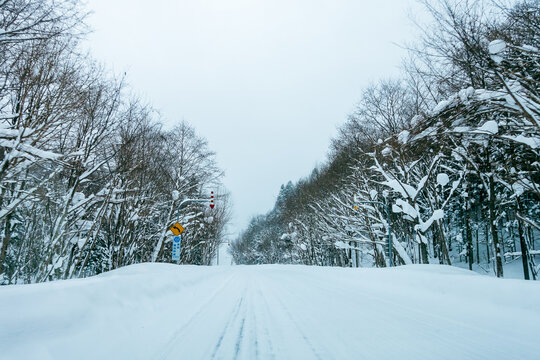 Hokkaido Bibai-Furano Line Rd 135 covered with snow in winter,the Japanese on the traffic sign reads "Tobetsu City Bibai to Furano Route 135"