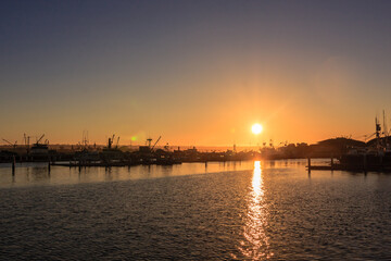 Fototapeta premium The sun is setting over the water