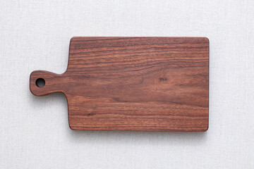 Walnut handmade wood cutting board on the linen. wooden cutting board isolated