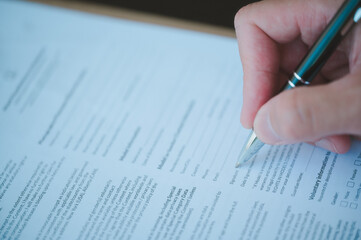 Businessman signing a legal document, executive manager hand filling paper business document, signing contract, partnership agreement, close up
